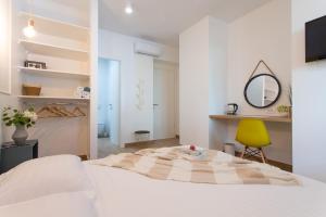 um quarto branco com uma cama e uma cadeira amarela em Sweet rooms em Split