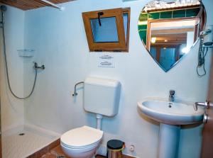 a bathroom with a toilet and a sink and a mirror at Bazart Vama Veche in Vama Veche