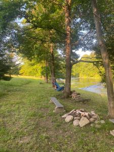 ルトビスカにあるDomki u Gretkaのベンチと木々と川のある公園