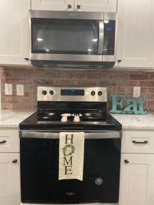 a kitchen with a black stove with a microwave at Cozy 2-bedroom Farmhouse with parking on premise in Smyrna