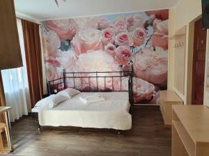 コスティネシュティにあるVila Pacificのピンクのバラの壁画が飾られたベッドルーム