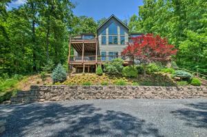 a house on a hill with a stone wall at Grand Chalet with Hot Tub - Near Wintergreen Resort in Wintergreen