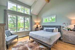 a bedroom with a bed and a chair and windows at Grand Chalet with Hot Tub - Near Wintergreen Resort in Wintergreen