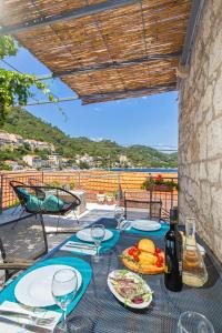 a table with plates of food and wine glasses at Apartman Daniela in Sobra