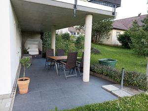 um pátio com uma mesa e cadeiras sob um telhado em Ferienwohnung Abendsonne em Horgenzell
