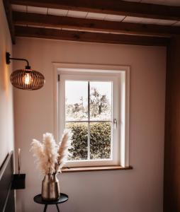 een raam in een kamer met een vaas met bloemen bij -NIEUW- Luxe & sfeervol Vakantiehuis Tholen in Tholen