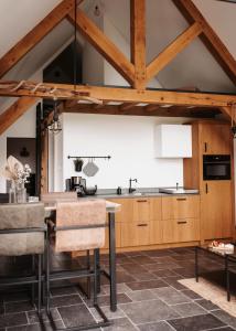 una cocina con armarios de madera, mesa y sillas en -NIEUW- Luxe & sfeervol Vakantiehuis Tholen, en Tholen