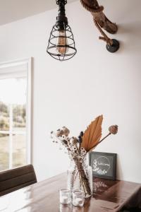 a table with a vase with flowers and a light at -NIEUW- Luxe & sfeervol Vakantiehuis Tholen in Tholen