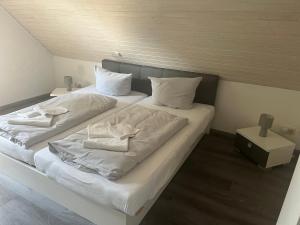 two beds in a room with white sheets and towels at Ferienhaus Muschel in Kalkhorst