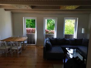 a living room with a couch and a table and windows at Ferienhaus Muschel in Kalkhorst