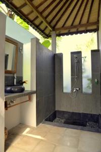 a bathroom with a shower and a sink at Prashanti Bali in Ubud