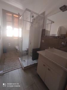 ein Bad mit einer Glasdusche und einem Waschbecken in der Unterkunft Amanda casa vacanza in Avola