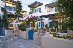 a row of white buildings with blue doors at George's beach studios Aliki Paros in Aliki