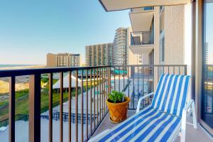 Un balcón con una silla azul y blanca y el océano. en Sea Colony --- 401 Dover House, en Bethany Beach