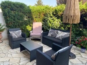 a patio with chairs and a table and a umbrella at maison Basque Maïana in Anglet