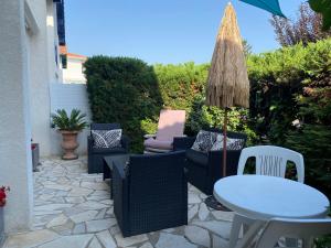 patio con sedie, tavolo e ombrellone di maison Basque Maïana ad Anglet