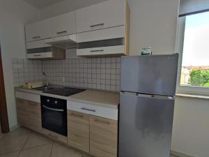 een keuken met een roestvrijstalen koelkast en kasten bij Three Lions Apartment in Pula