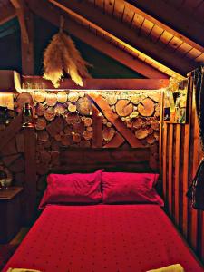a bedroom with a red bed in a log cabin at Life on the farm in Nepravishtë