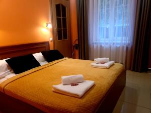a hotel room with a bed with towels on it at Guest house POILSIS JUMS in Klaipėda