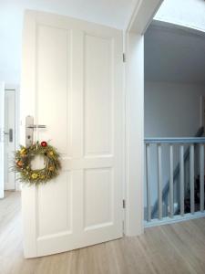 a white door with a wreath on it in a room at Familienhof Müritz in Klein Plasten