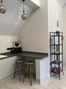 a kitchen with a counter and two stools at Cosy cottage in the heart of the Cotswolds in Cirencester