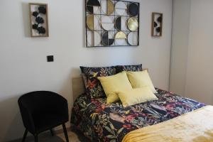 a bedroom with a bed and a chair at Studio Les pieds dans l'eau in Dieppe