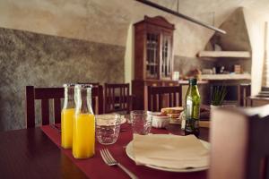 a table with a bottle of orange juice and glasses at Can Manseu in Sant Privat de Bas +20 photos