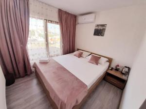 a bedroom with a large bed and a window at Pensiunea Albert in Hîrşova