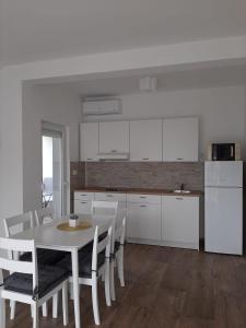 a kitchen and dining room with a table and chairs at Elegant Inn Gospić in Gospić