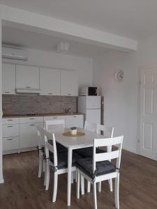 a white kitchen with a white table and chairs at Elegant Inn Gospić in Gospić