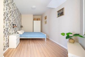 ein Schlafzimmer mit einem Bett und einer Topfpflanze in der Unterkunft Apartament ALGA2 in Darłowo