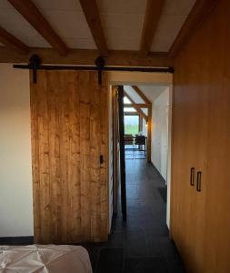 een slaapkamer met een houten deur en een kamer met een tafel bij -NIEUW- Luxe & sfeervol Vakantiehuis Tholen in Tholen