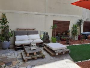 a patio with a couch and a table and an umbrella at Studio Terrasse Proche Palais des Festivals in Cannes