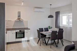 a kitchen and dining room with a table and chairs at Apartment Stocic in Rogoznica