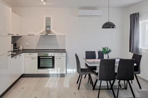 a kitchen and dining room with a table and chairs at Apartment Stocic in Rogoznica