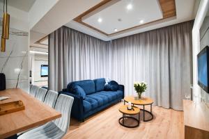 salon z niebieską kanapą i stołem w obiekcie Boutique 62 by Housine w Zatorze