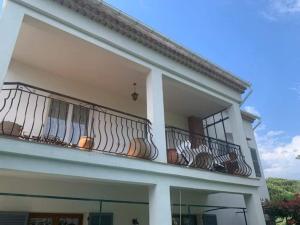 - un bâtiment blanc doté d'un balcon avec vue sur le ciel dans l'établissement Appartement indépendant dans villa, entre Fréjus et St Raphaël, à Fréjus
