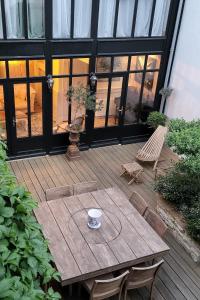 a wooden patio with a wooden table and chairs at La Martinoise Patio in Saint-Martin-de-Ré