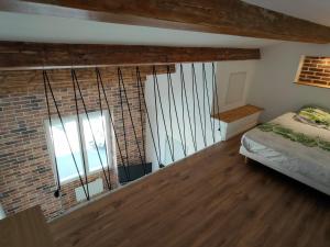 a bedroom with a bed and a brick wall at Joli apparemment type Loft in Cavaillon