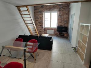 a living room with a glass table and red chairs at Joli apparemment type Loft in Cavaillon