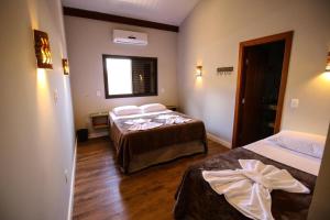 a hotel room with two beds and a window at Suítes Novas no Coração de Bonito in Bonito