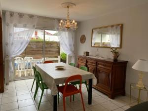 - une salle à manger avec une table, des chaises et un miroir dans l'établissement maison Basque Maïana, à Anglet