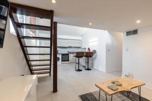a living room with a staircase and a table at Superbe appartement en plein centre du vieil Antibes in Antibes