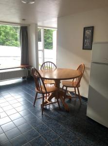 eine Küche mit einem Tisch und Stühlen sowie einem Kühlschrank in der Unterkunft The Guesthouse by the Fjord in Þingeyri