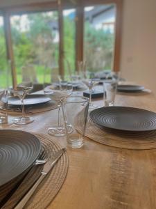 una mesa de madera con platos y copas de vino. en Bungalow in Rottachs Bestlage, en Rottach-Egern