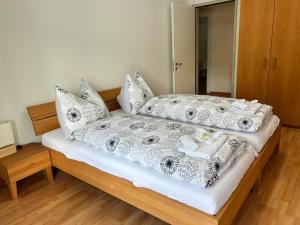 - une chambre avec un lit doté de draps et d'oreillers blancs dans l'établissement Ferienhaus Rütiboda bis 20 Personen, à Davos