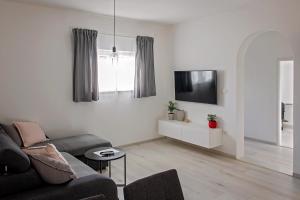 a living room with a couch and a tv at Apartment Stocic in Rogoznica +4 photos