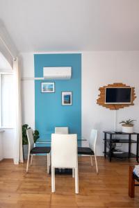 comedor con pared azul, mesa y sillas en Apartman Eta en Opatija