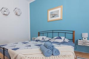 Un dormitorio azul con una cama con toallas. en Apartman Eta en Opatija