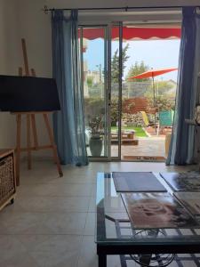 ein Wohnzimmer mit einem Klavier und einem Glastisch in der Unterkunft Studio Terrasse Proche Palais des Festivals in Cannes